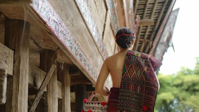 Ilustrasi perempuan Batak di Rumah Bolon.